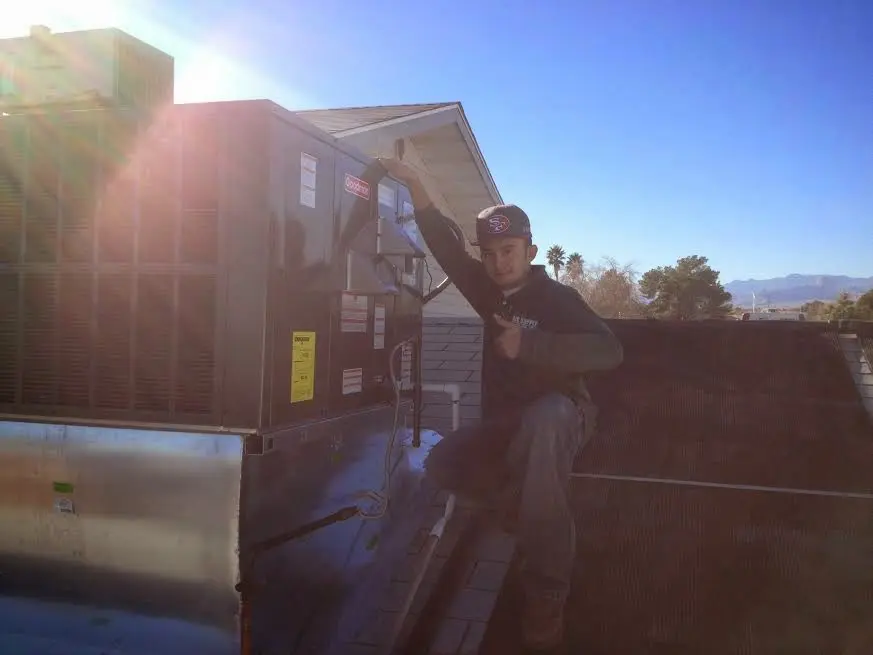 HVAC technician performing HVAC Inspection on a rooftop unit in Charlestown